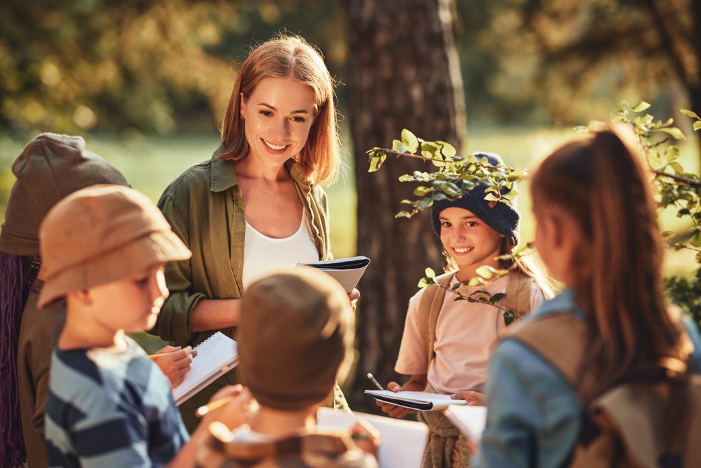 group,of,curious,school,children,with,notebooks,listening,to,their